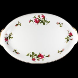 Puede incluir: Plato de servir ovalado blanco con borde dorado y dise&ntilde;o floral de rosas rosas y hojas verdes.