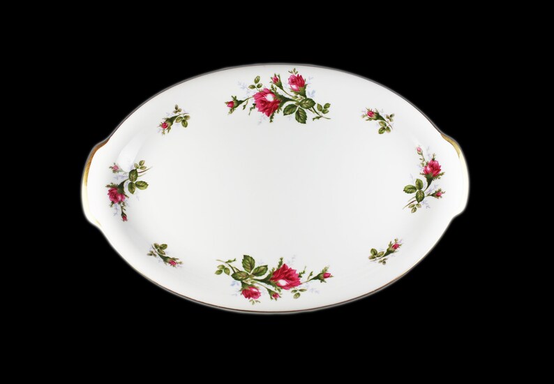 Puede incluir: Plato de servir ovalado blanco con borde dorado y dise&ntilde;o floral de rosas rosas y hojas verdes.