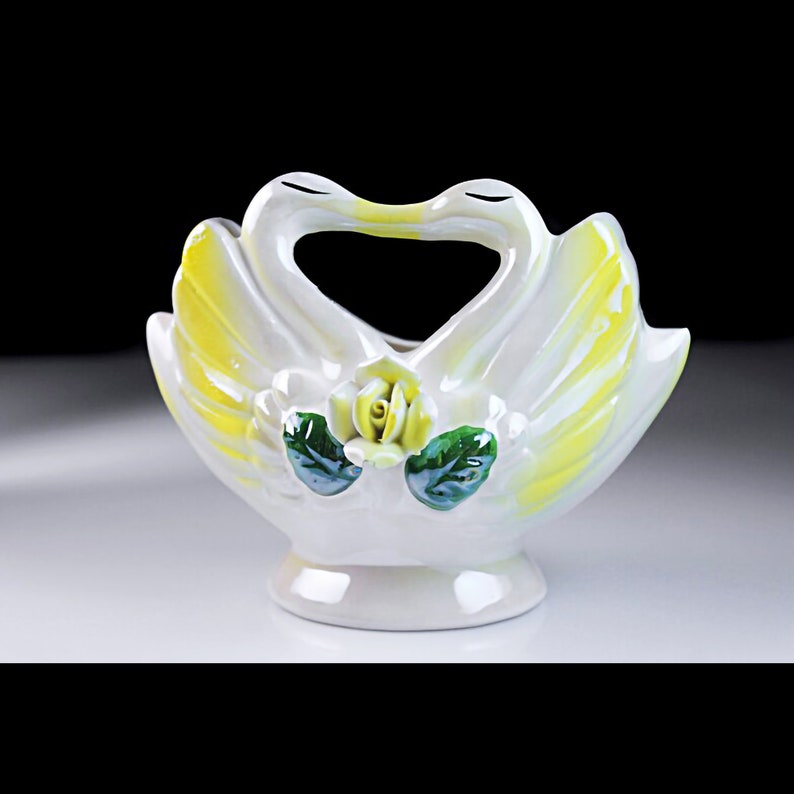 May include: White ceramic swan-shaped bowl with yellow accents and a green and yellow rose decoration.