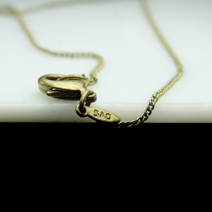 May include: A gold chain necklace with a clasp that has the inscription "925" on it.