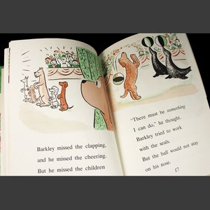 May include: A brown dog with a black nose watches a group of seals balancing balls on their noses. The seals are black with white stripes. The dog is looking at the seals with a curious expression. The text "There must be something I can do." is written in the bottom right corner of the page.