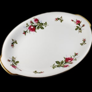 Puede incluir: Plato de servir ovalado blanco con borde dorado y dise&ntilde;o floral con rosas rosas y hojas verdes.