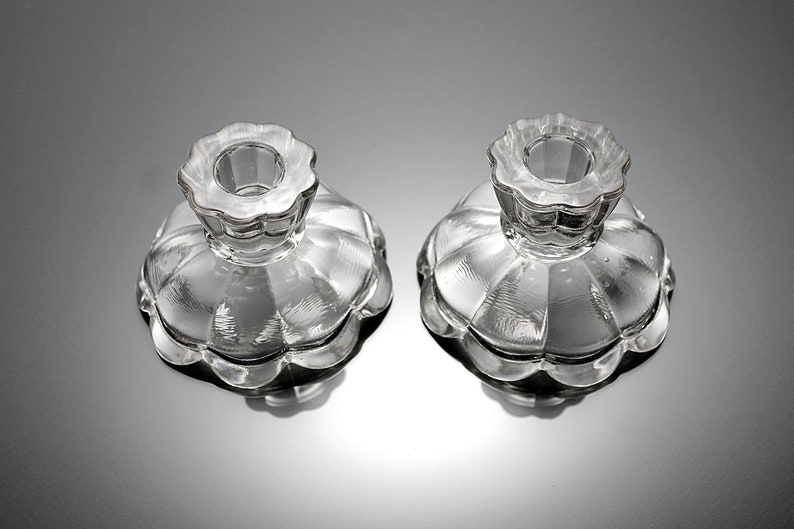 Puede incluir: Dos candelabros de vidrio transparente con borde festoneado y dise&ntilde;o acanalado. Los candelabros est&aacute;n vac&iacute;os y listos para usar.