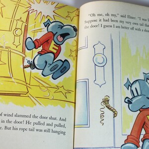 May include: A cartoon dog with a blue body and red shirt with a white letter E is stuck in a yellow door. The dog is pulling on a rope tail. The text in the image reads "Oh me, oh my, said Elmer. "I was lucky that time Suppose it had been my very own tail that was caught in the door! I guess I am better off with a short tail"