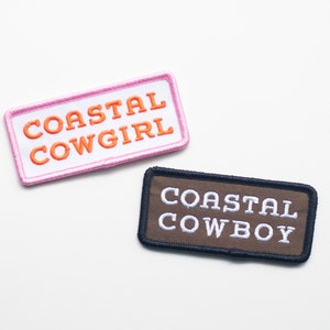 May include: Two embroidered patches, one pink with white stitching and the text "COASTAL COWGIRL" in orange, and one brown with black stitching and the text "COASTAL COWBOY" in white.