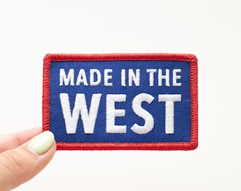 May include: Blue and red embroidered patch with white text that reads "MADE IN THE WEST".
