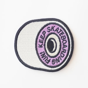 May include: White embroidered patch with a purple wheel and the text "Keep Skateboarding Fun".