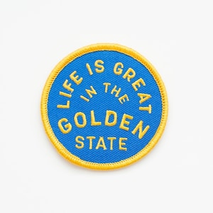 May include: A blue and yellow embroidered patch with the text "Life is Great in the Golden State".