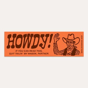 May include: An orange rectangular sticker with the word "HOWDY!" in brown, stylized lettering. Below, the text reads, "IF YOU CAN READ THIS, QUIT TAILIN' MY WAGON, PARTNER." A cartoon cowboy waves on the right. The website address is visible.