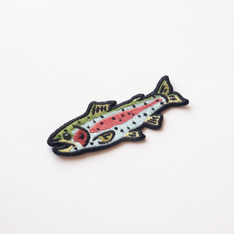 May include: An embroidered iron-on patch of a rainbow trout fish with black outlines, green, yellow, red, and blue details.