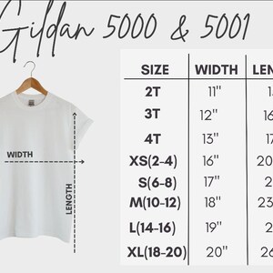 May include: A white t-shirt hanging on a wooden hanger, with a size chart for Gildan 5000 & 5001 shirts. The chart lists sizes from 2T to XL, with corresponding widths and lengths in inches. The text "Gildan 5000 & 5001" is at the top.