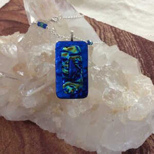 Colored glass pendant with added beads on metal chain