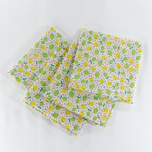 May include: Four white cotton napkins with a lemon and dot pattern in shades of green, yellow, pink, and blue.