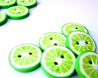 May include: Green lime-shaped buttons with a white center and a buttonhole. The buttons are arranged in a semi-circle.
