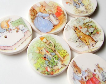 May include: Six round ceramic buttons with images of Peter Rabbit and his friends. The buttons feature scenes from the classic children's book, including Peter Rabbit in the garden, Peter Rabbit having tea, and Peter Rabbit with his siblings.