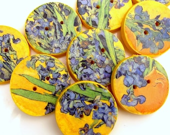 May include: Ten round wooden buttons with a yellow background and a blue floral design. The buttons have two holes each.