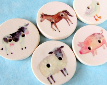 May include: Five round white ceramic buttons with different farm animal illustrations. The buttons feature a cow, horse, pig, sheep, and goose.
