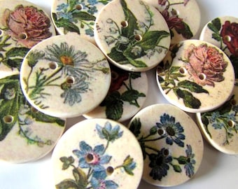 May include: A collection of 12 round wooden buttons with floral designs. The buttons feature various flowers, including roses, daisies, and forget-me-nots, in shades of pink, blue, and white.
