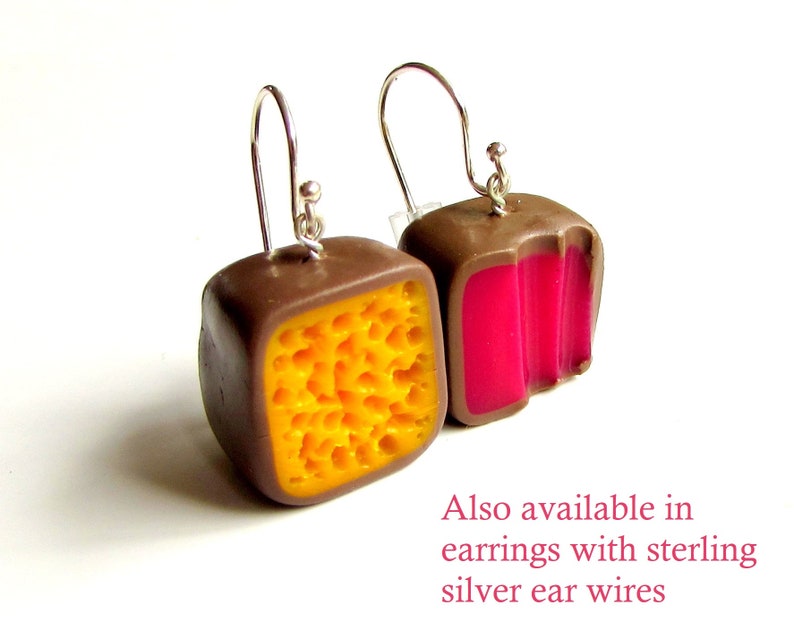 May include: A pair of earrings with a brown, yellow, and pink geometric design. The earrings are made of polymer clay and have silver ear wires. Also available in earrings with sterling silver ear wires.
