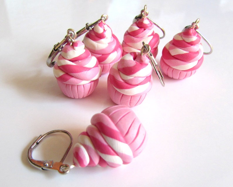 May include: Five pink and white swirl cupcake charm earrings with silver hooks.