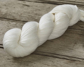 May include: A skein of white yarn, a soft and fluffy material for knitting or crocheting.