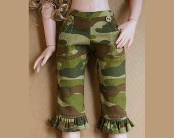 Pode incluir: Calças de estampa camuflada com bainha franjada. As calças têm dois fechos de botão na cintura.