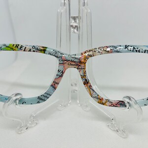 May include: A pair of blue eyeglasses with a map of the British Isles printed on the frames. The map includes the text "IRELAND" and "UNITED KINGDOM".