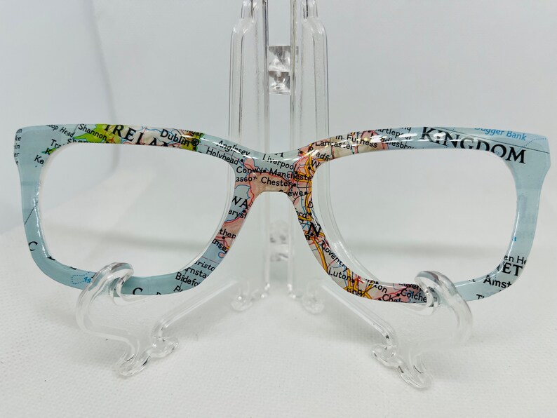 May include: A pair of blue eyeglasses with a map of the British Isles printed on the frames. The map includes the text "IRELAND" and "UNITED KINGDOM".