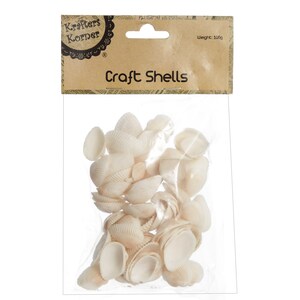 Puede incluir: Una bolsa de conchas blancas para manualidades, que pesa 100g, etiquetada como "Craft Shells" y "Krafers Korner".