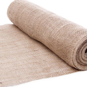 Pode incluir: Um rolo de tecido de juta marrom natural. O tecido é tecido com uma trama solta e aberta e tem uma textura áspera.