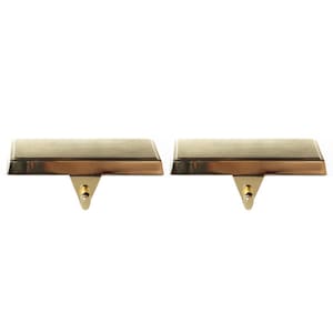 Op de afbeelding: Twee gouden metalen kousenhouders met een eenvoudig ontwerp. Elke houder heeft een platte rechthoekige basis en een kleine haak.