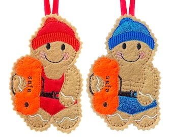 May include: Two gingerbread man ornaments, one in red swimwear and a red cap, the other in blue swimwear and a blue cap. Each holds an orange float with the word "safe". Both have red ribbon hangers.