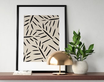 May include: A black framed print with a beige background and black abstract lines. A gold dome lamp sits on a wooden shelf with a potted green plant.