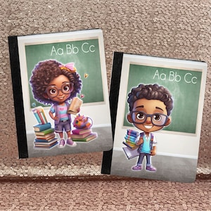 Puede incluir: Dos cuadernos de composición de estilo pizarra verde con lomos negros. Los cuadernos presentan ilustraciones de niños con gafas y mochilas. El texto "Aa Bb Cc" está impreso en cada cuaderno.