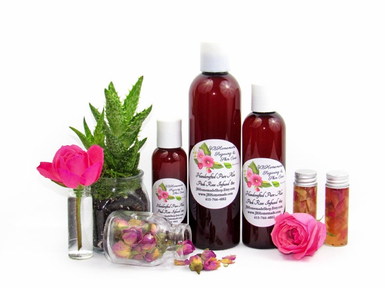 Three sizes of JBHomemade Pink Rose Infused Aloe Vera Gel displayed with fresh pink roses and aloe vera leaves. All-natural for soothing & hydrating skin.