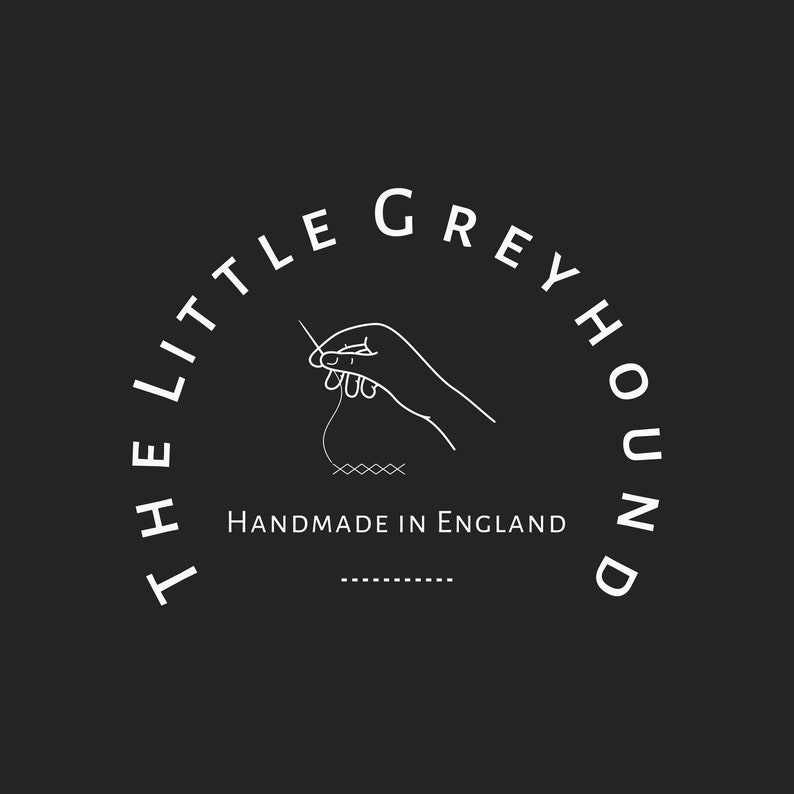 May include: Circular logo on a black background. The text "THE LITTLE GREYHOUND" arches around the top. A hand with a needle and thread is in the center. Below, the text reads "HANDMADE IN ENGLAND".