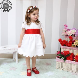 Robe de mariée blanche pour fille avec un grand nœud dans le dos. Pour demoiselles d'honneur. Encolure vague, manches courtes et ceinture.