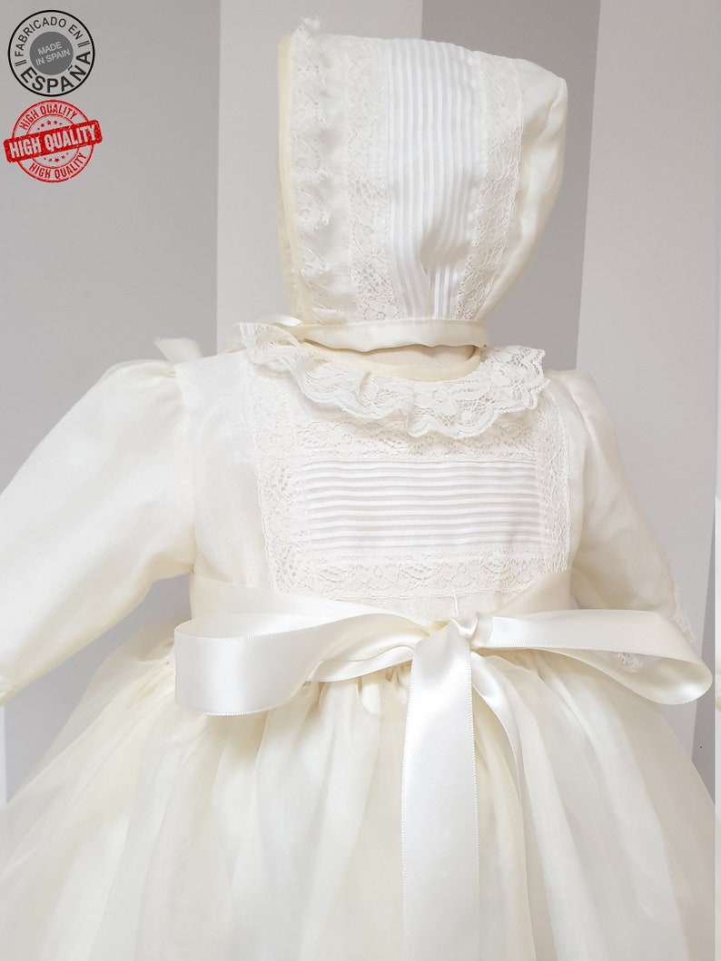 Peut inclure: Une robe de bapt&ecirc;me blanche avec une bordure en dentelle et un n&oelig;ud en satin. La robe a des manches longues et une jupe ample. La robe est faite d'un tissu de haute qualit&eacute; et est parfaite pour une occasion sp&eacute;ciale.