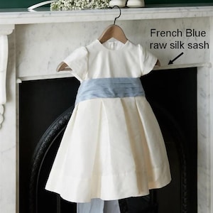 Robe de mariée royale classique et élégante pour fille. Soie ivoire douce avec ceinture ivoire. Grand nœud. Manches bouffantes. Robe de mariée pour fille. Cancan.