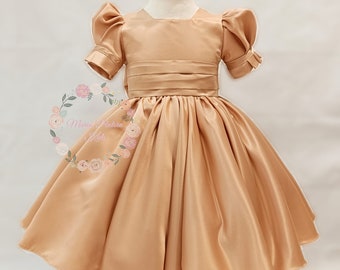 Classic style formal dress for girls, perfect for a royal wedding. Champagne color, V-neck back, large bow. Satin. Made in Spain