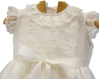 Robe de baptême en organza ivoire pour fille, avec bordure en dentelle et nœud. Idéale pour les grandes occasions : cérémonies chrétiennes, mariages, anniversaires.