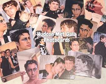 May include: A collection of Hudson Met Gala photocards featuring various portraits of a person with dark eye makeup and stylish attire. The cards are rectangular with rounded corners, and the text "Hudson Met Gala Photocards" is visible.