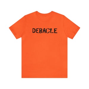 Könnte beinhalten: Orangefarbenes T-Shirt mit dem Wort "DEBACLE" in Schwarz gedruckt.