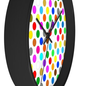 May include: A black framed clock with a white face and a colorful polka dot pattern. The clock hands are black.