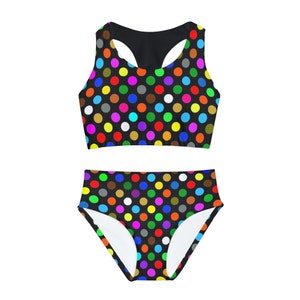 May include: A black swimsuit with a colorful polka dot pattern. The top has a racerback style and the bottom is a high-waisted bikini bottom.