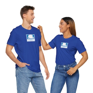 Può includere: Due persone indossano magliette blu reale con un logo bianco che dice "White Cloud Mountain Outfitters". Il logo presenta una silhouette bianca di una catena montuosa con alberi. Le persone sono in piedi e si guardano.