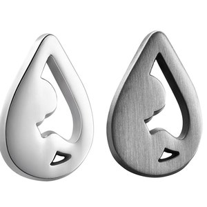 Puede incluir: Dos colgantes de metal plateado en forma de lágrima con un diseño recortado en el interior. Un colgante está pulido y el otro está cepillado.