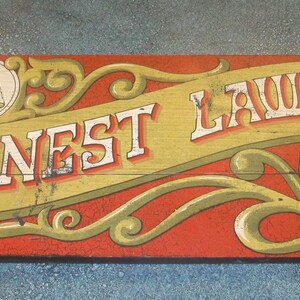 May include: A rectangular wooden sign with a red background and decorative green scrollwork. The text HONEST LAWYER is printed in white with red outlines. A circular icon of scales is on the left, and a circle with CONTRACTS CODICILS is on the right.