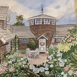 May include: Watercolor painting of a house with a round tower, surrounded by a garden of white and pink roses. The painting includes an American flag and a wreath on the front door. The artist's logo is in the bottom right corner.