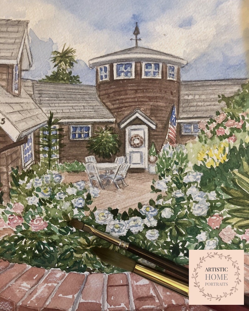 May include: Watercolor painting of a house with a round tower, surrounded by a garden of white and pink roses. The painting includes an American flag and a wreath on the front door. The artist's logo is in the bottom right corner.